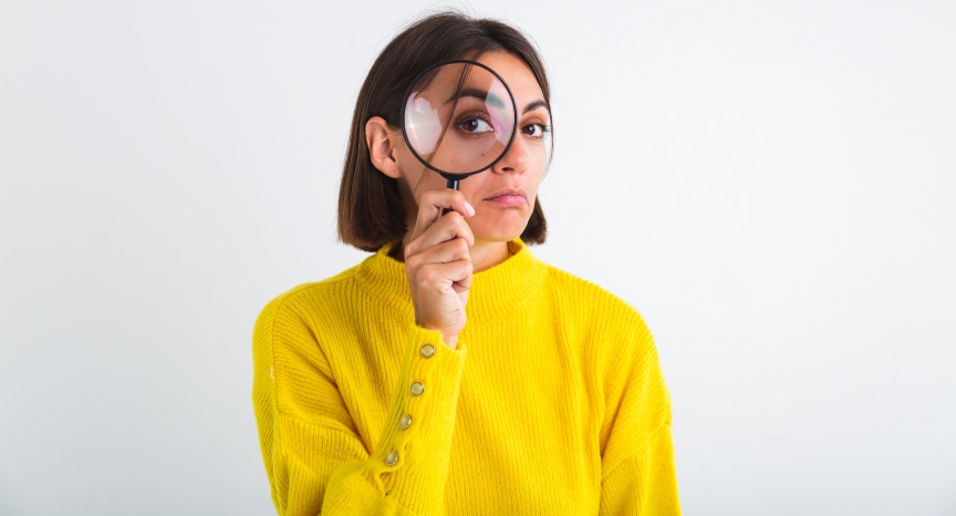 pretty-woman-yellow-sweater-white-held-magnifier-happy-positive-playful.jpg
